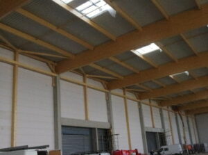 Charpente bois et exutoires de désenfumage en toiture d'un entrepôt logistique